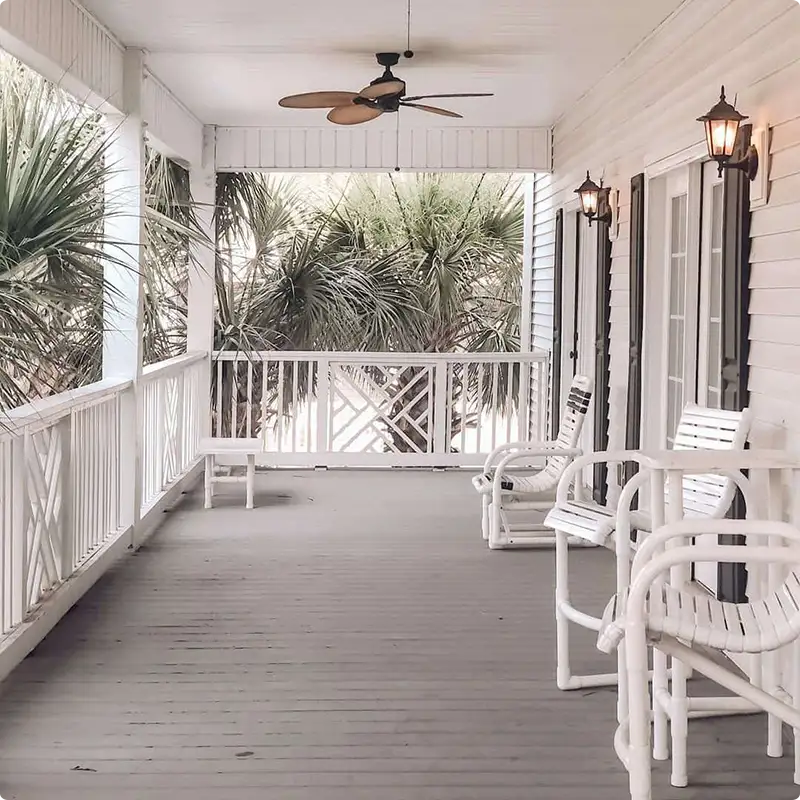Breezy Porch Vibes With White Railings and Ceiling Fans Spinning