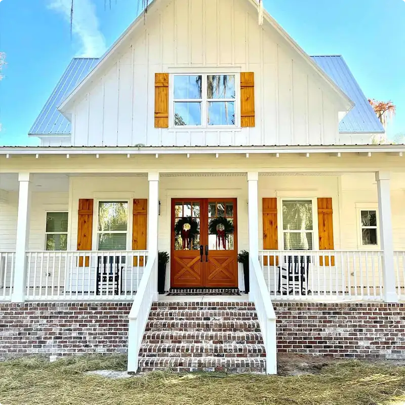 White Porch Railing Paired With a Brick Skirt